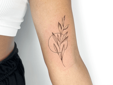 Elegant minimalistic tattoo of a plant design on an arm.