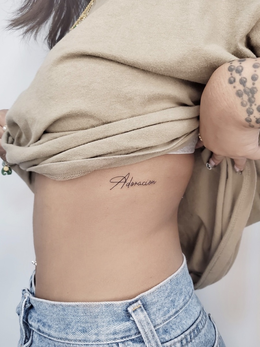 Tattoo reading 'Adoracion' on skin