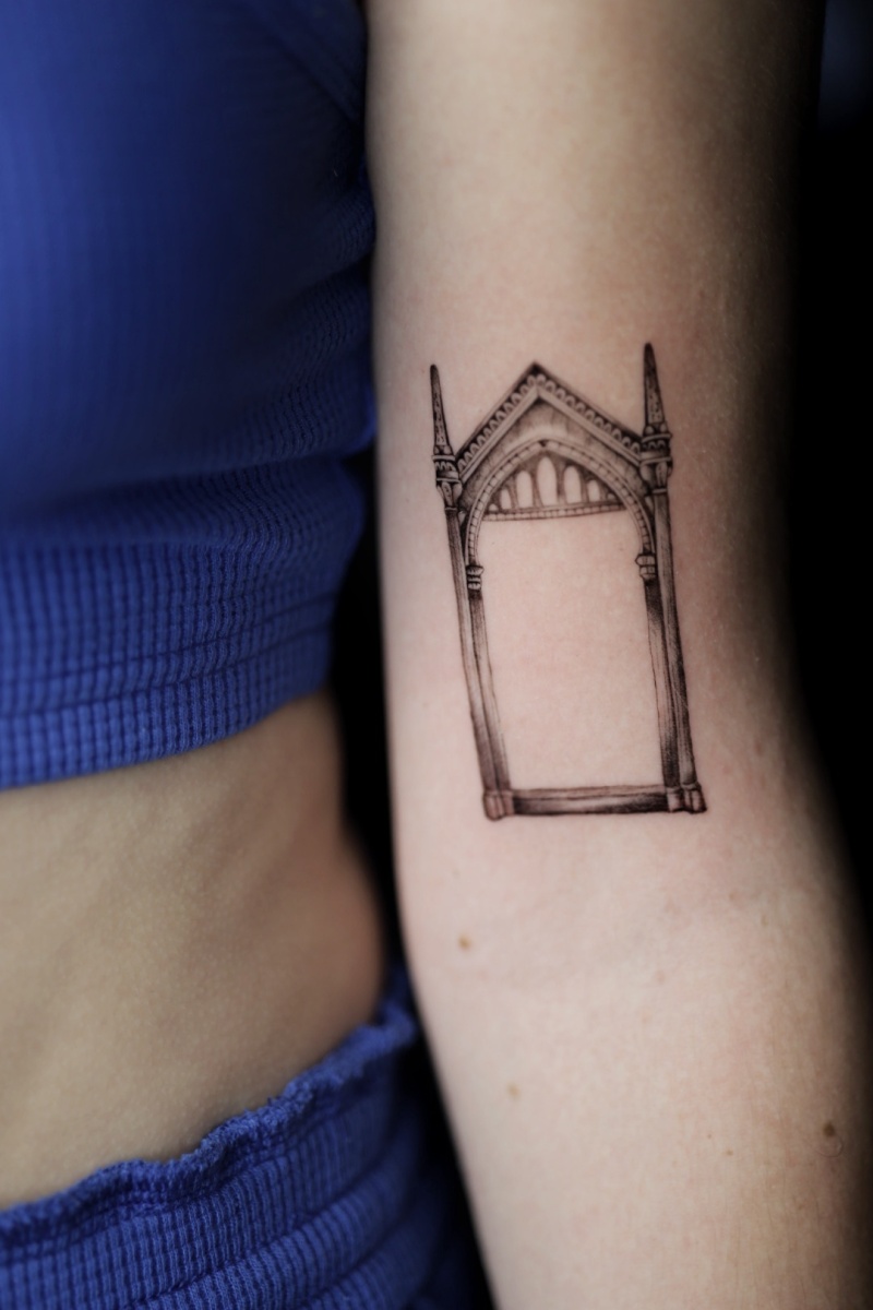 Tattoo of a gothic arch on a woman's arm