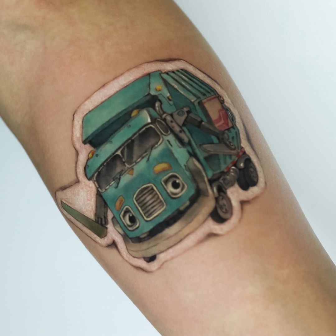 Colorful tattoo of a cartoon garbage truck on arm