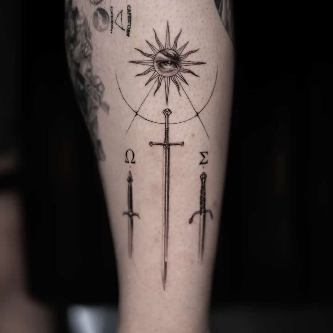 Detailed tattoo design featuring a sword, sun, and symbols