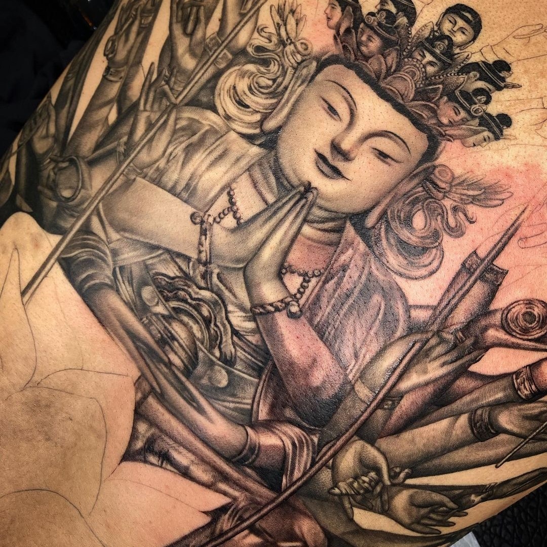 Detailed tattoo design depicting a Bodhisattva with multiple arms