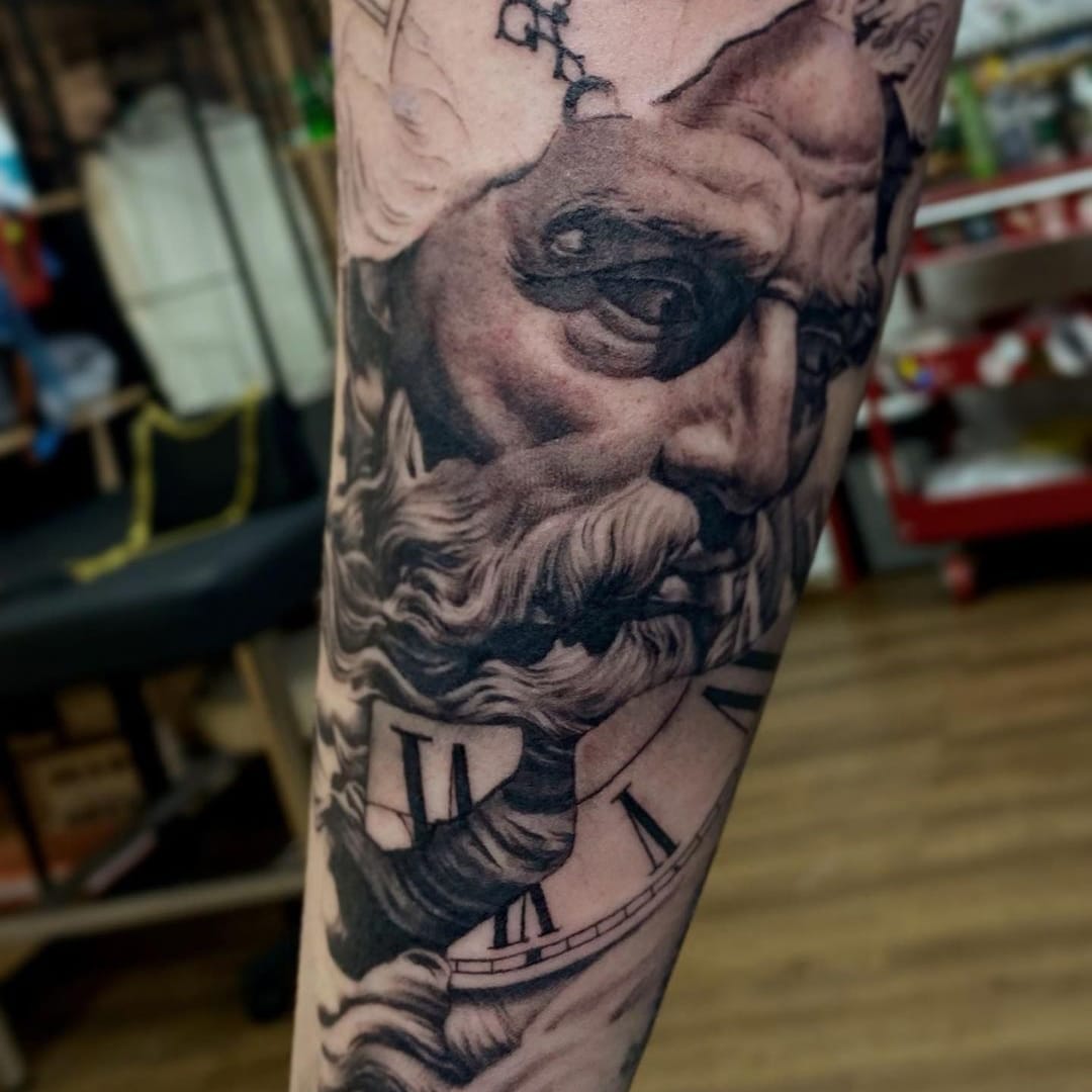 Detailed tattoo artwork depicting an elderly man's face with a clock