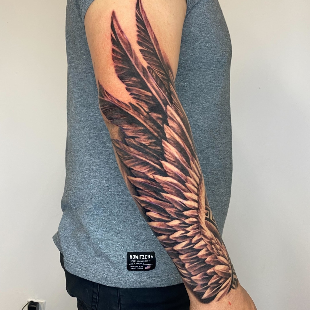 Tattoo of wings on a man's forearm