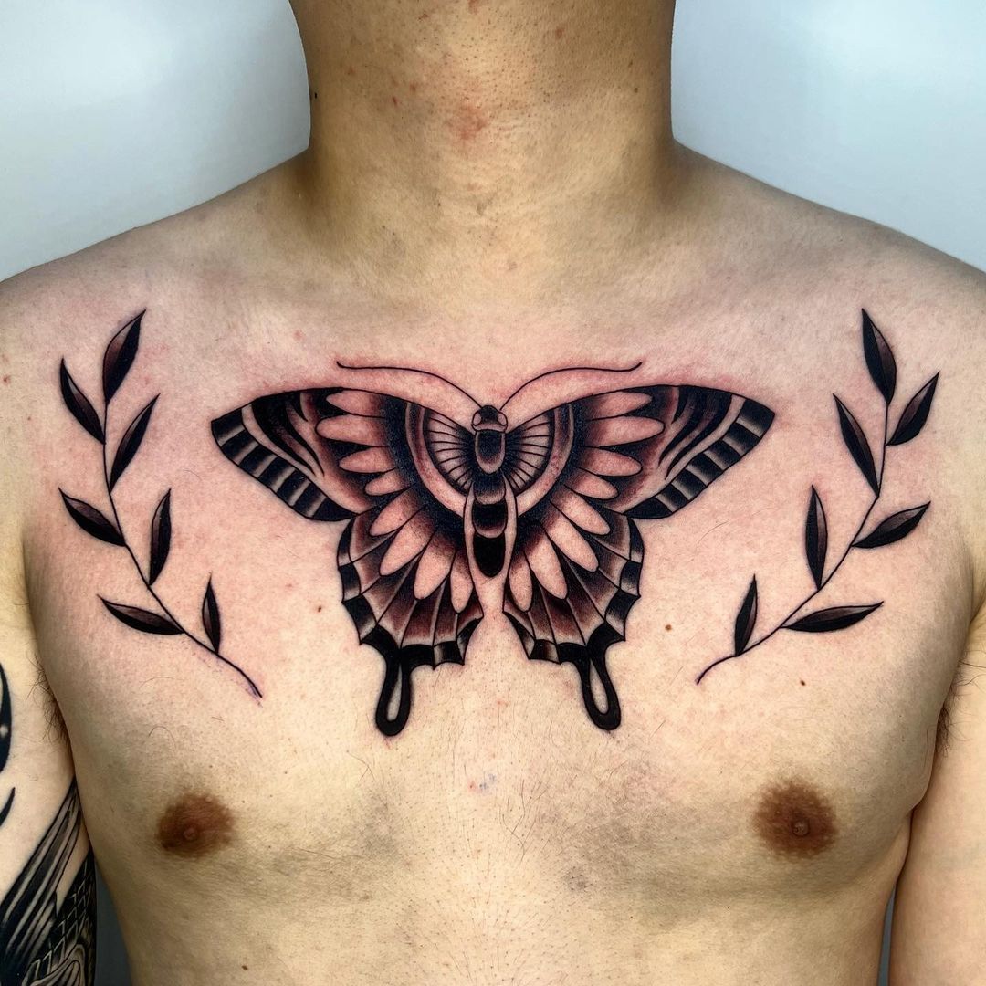 Black and grey butterfly tattoo on a man's chest