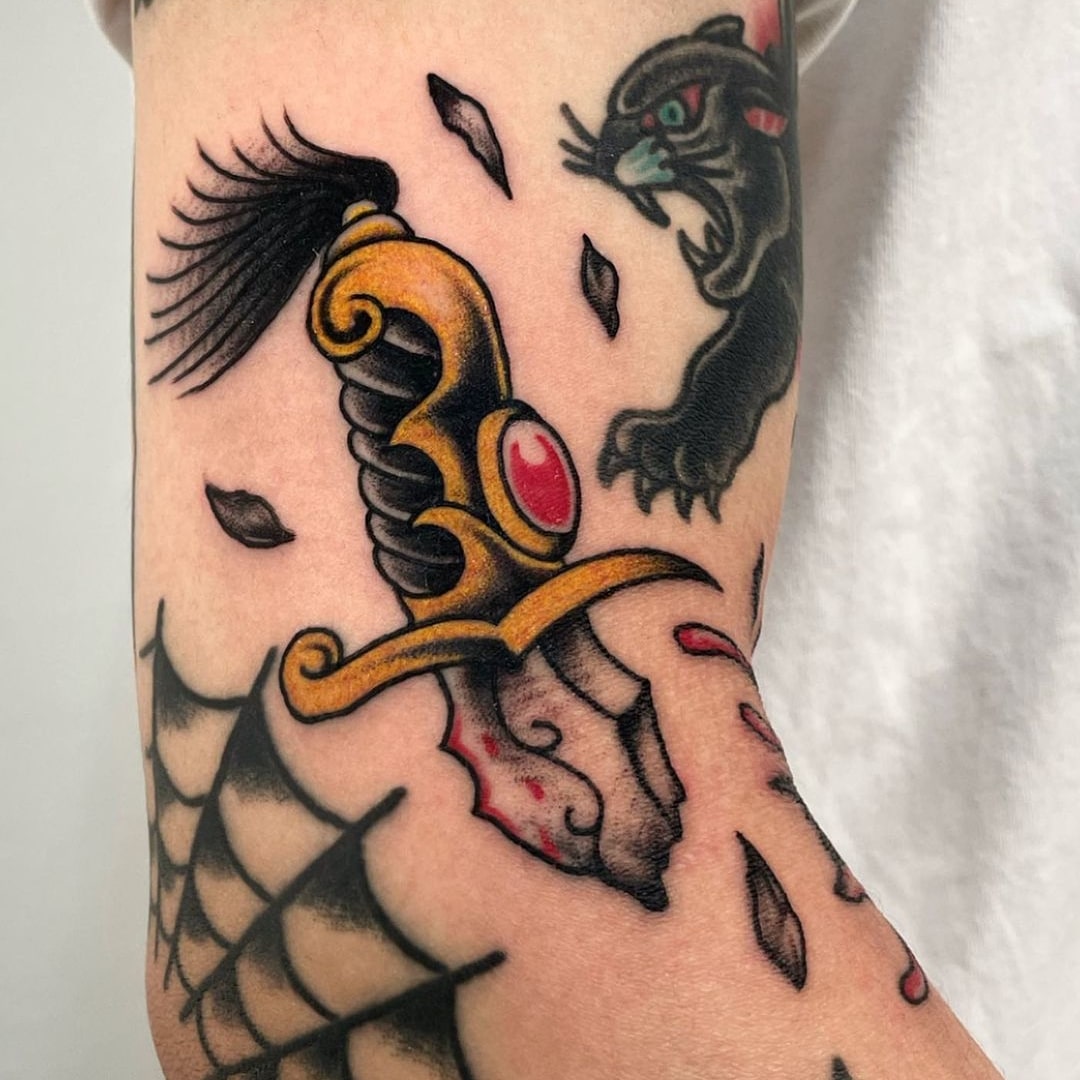 Colorful tattoo of a dagger and a panther