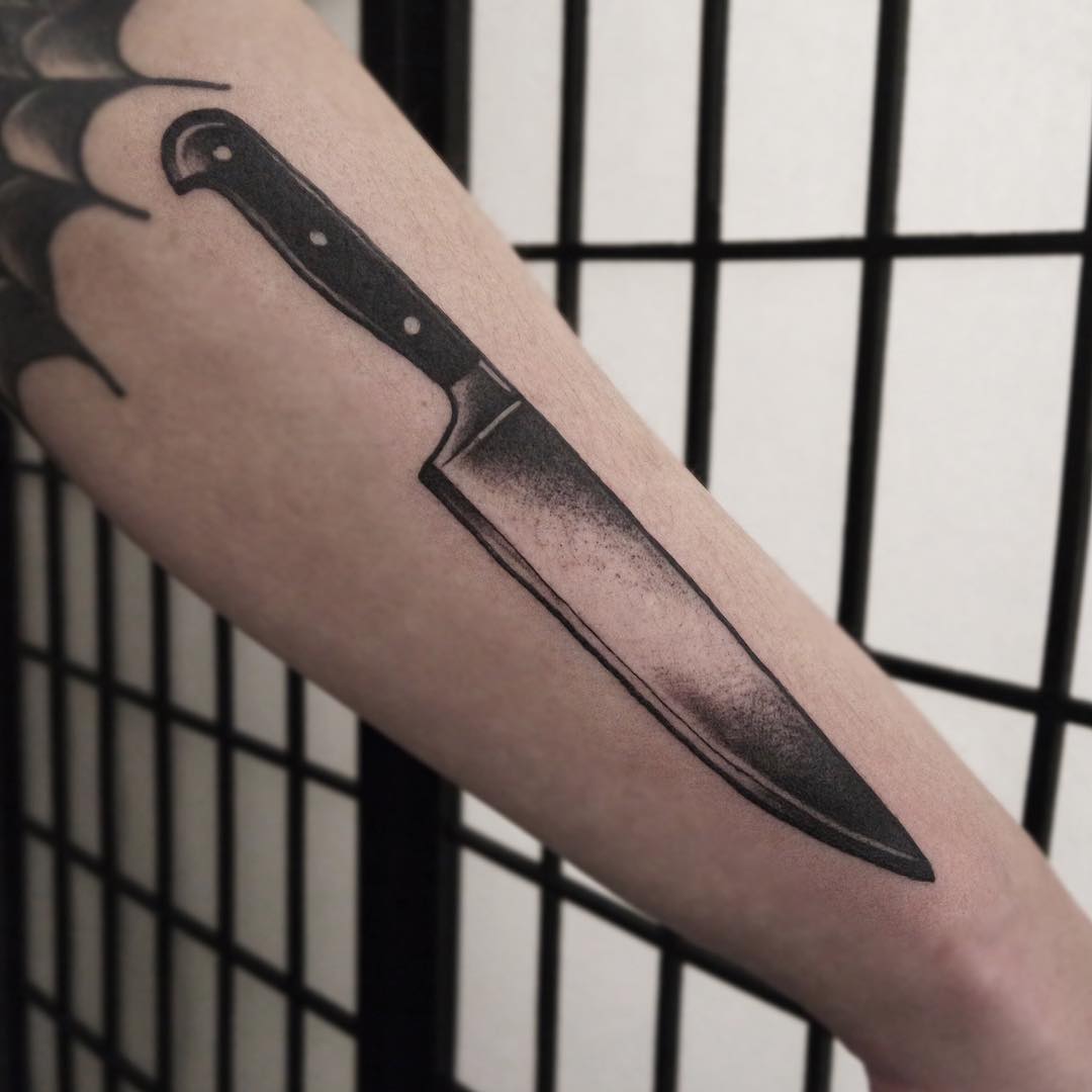 Realistic tattoo of a knife on an arm