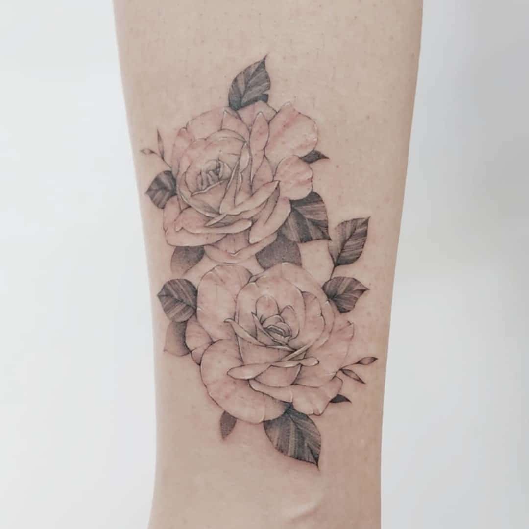 Delicate tattoo of two roses on a forearm