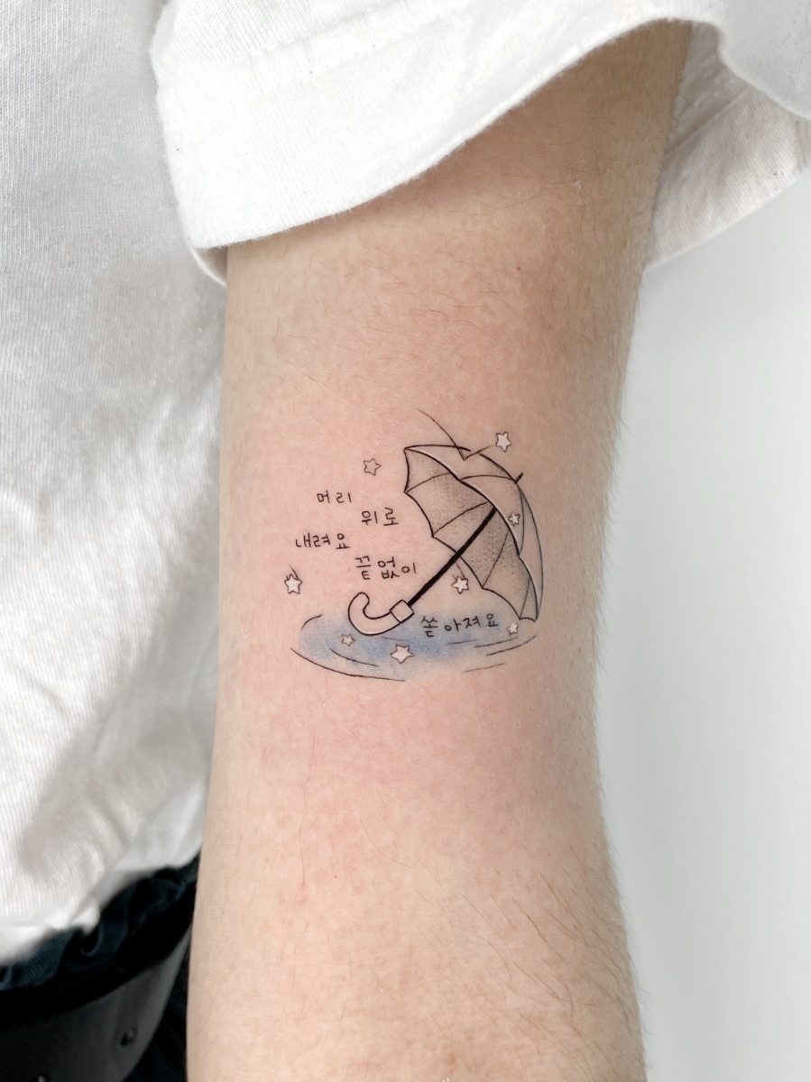 Tattoo design featuring an umbrella over water with text