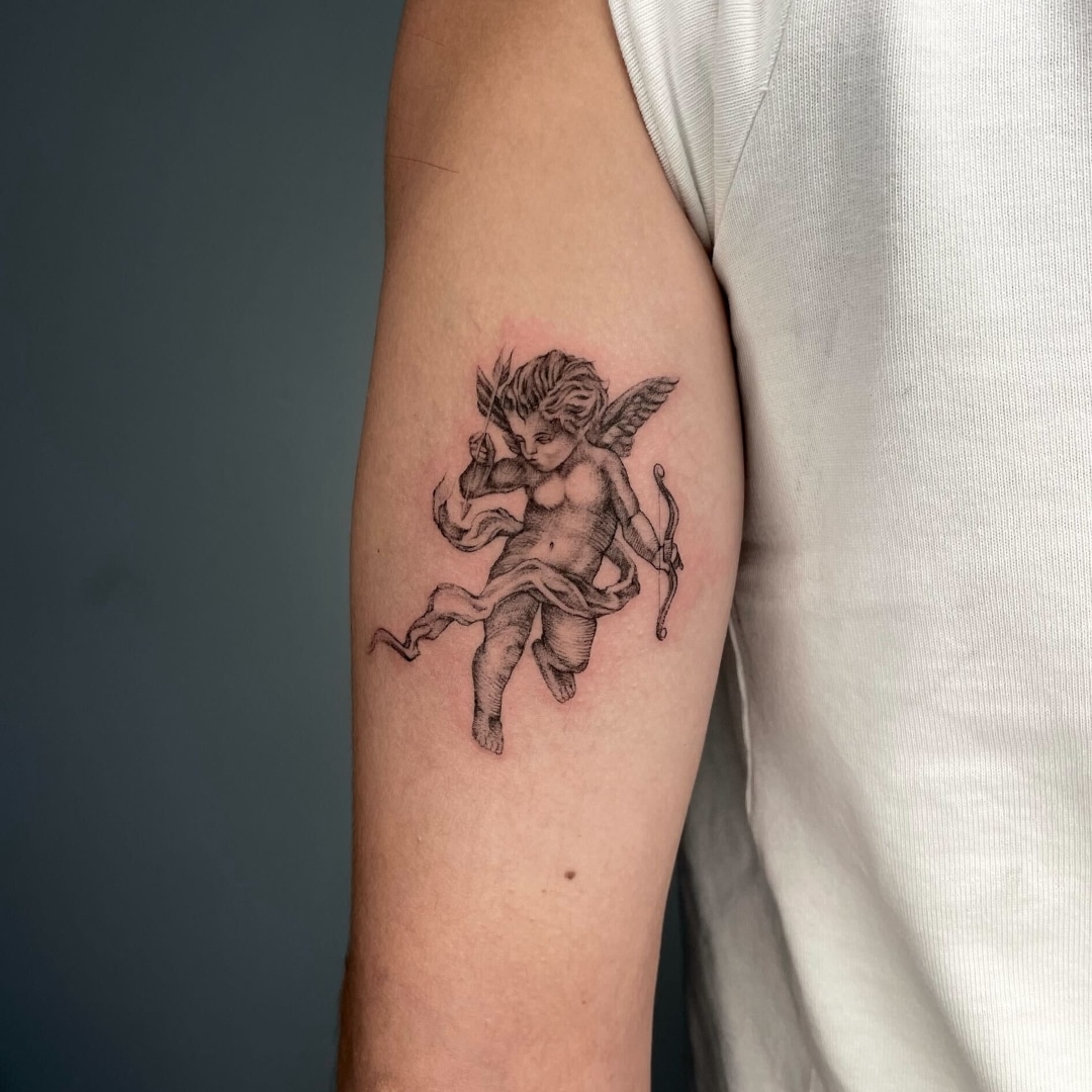 Tattoo of a winged cherub with a bow and arrow on arm