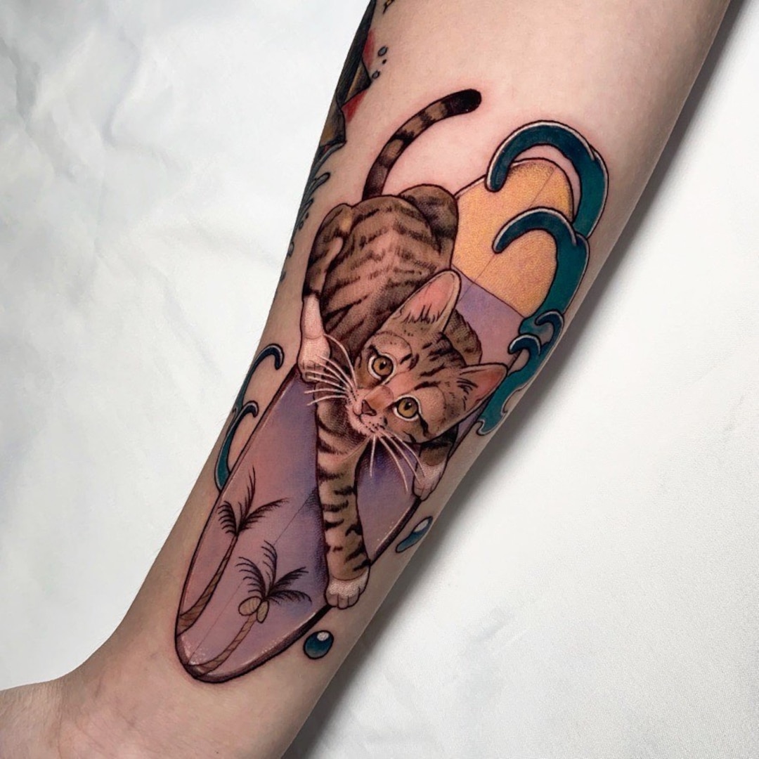 Tattoo of a tabby cat emerging from waves.