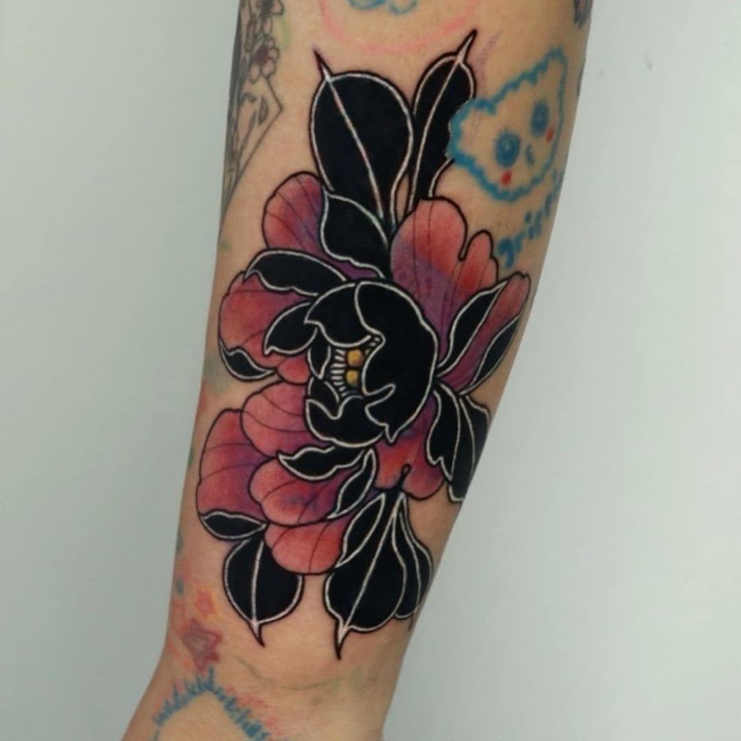 Colorful floral tattoo on arm featuring pink and black hues