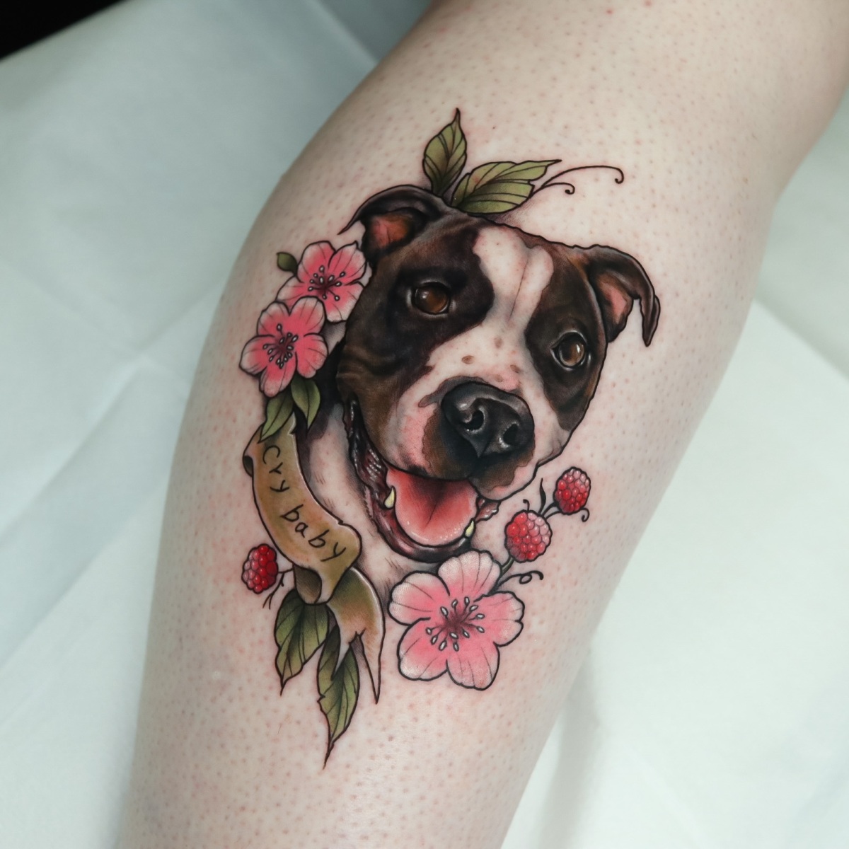 A colorful tattoo of a dog surrounded by flowers.