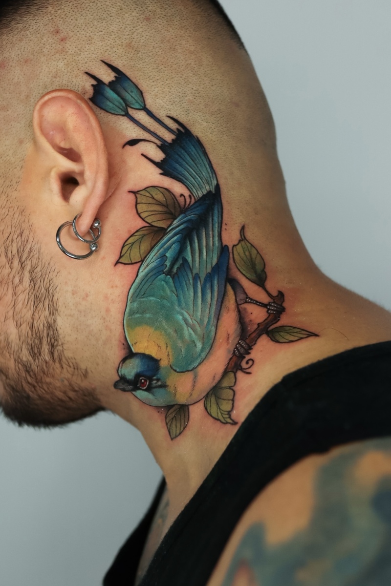 Colorful bird tattoo on the neck of a man